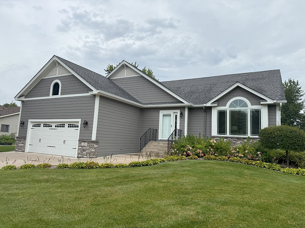 Lino Lakes, MN home with James Hardie Aged Pewter siding, Arctic White trim, and cultured stone.